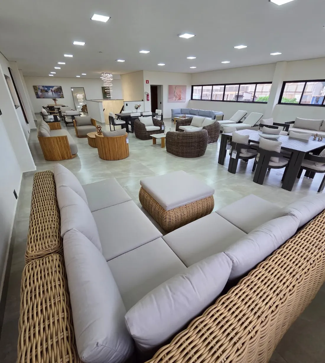 Showroom da Garmanii em Cravinhos, SP, com sofás em rattan e teca e mesas de jantar em alumínio